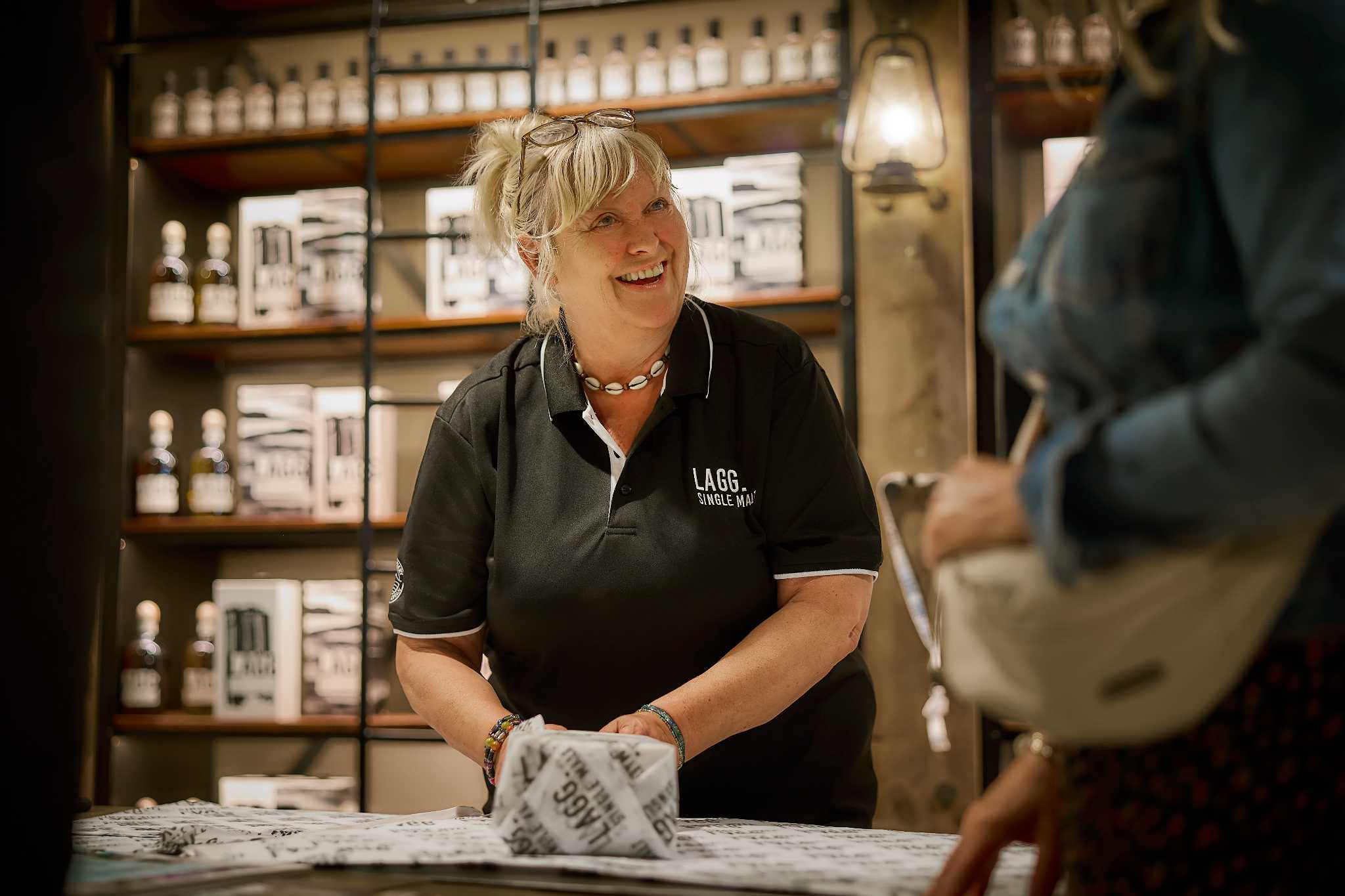 A cheerful assistant serves a customer