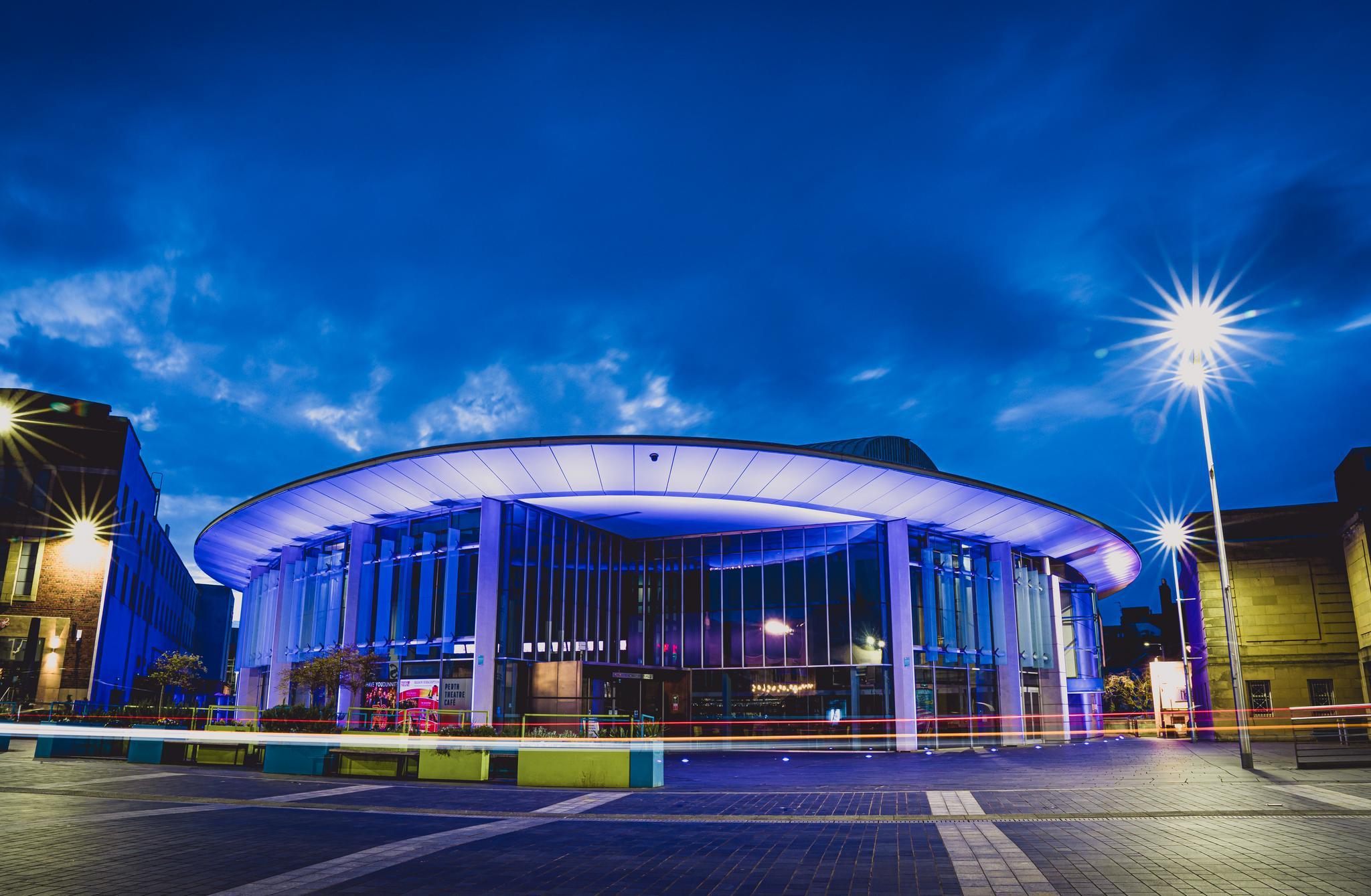 Exterior shot of the Perth Concert Hall lit up by atmospheric lighting at night
