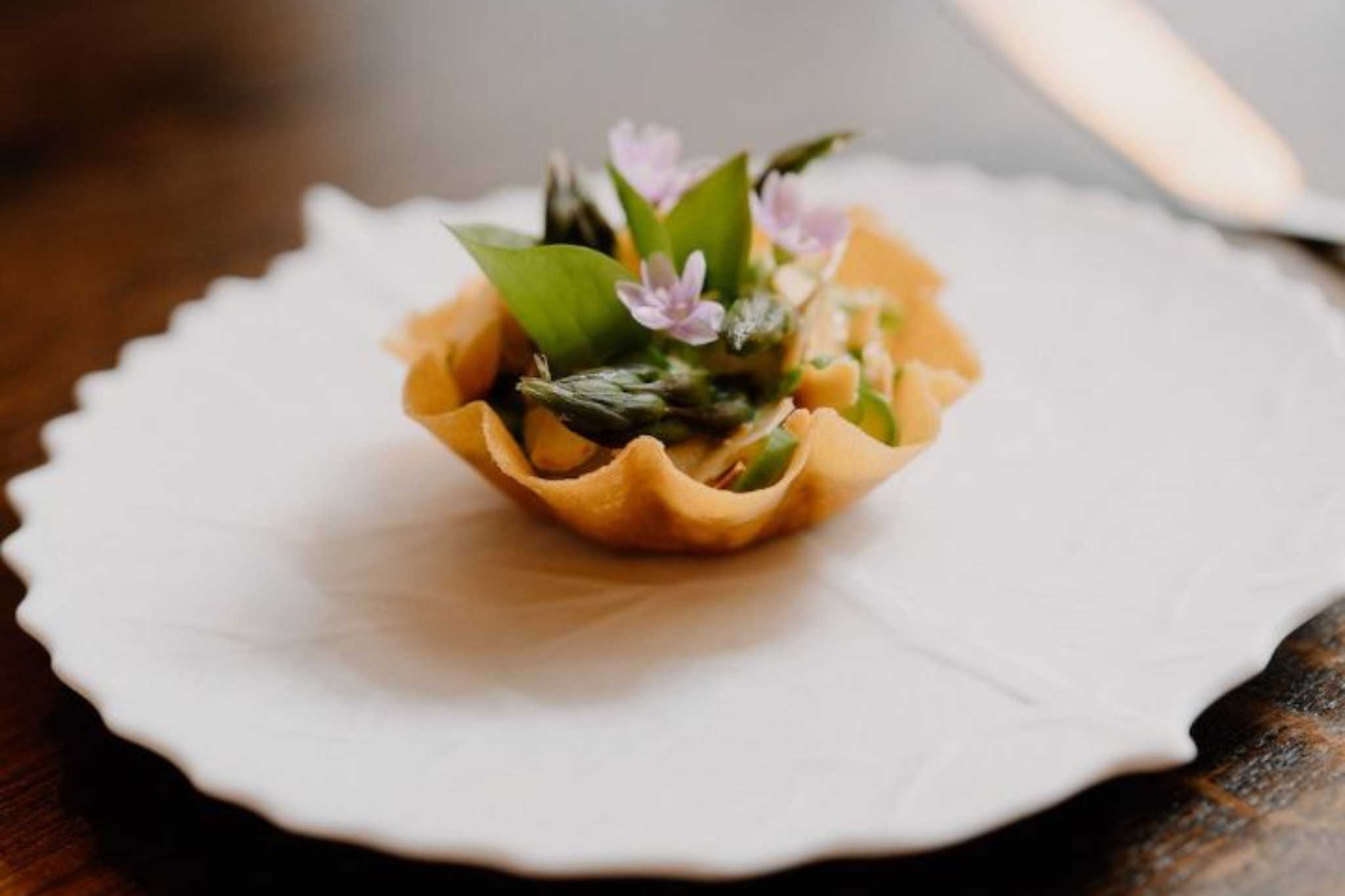 A plate with a stuffed shell garnish with a herb