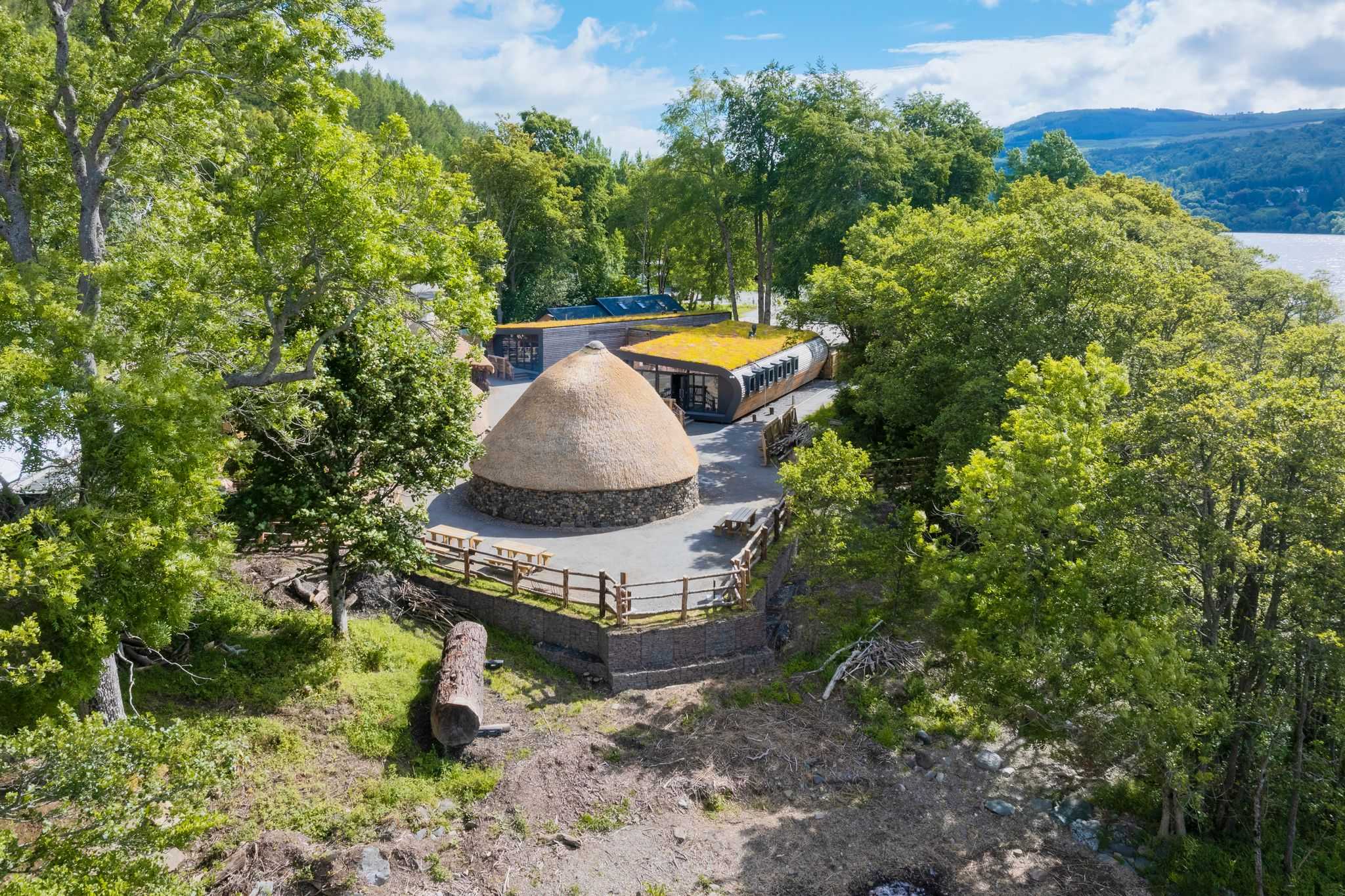 exterior image of site with flat walking areas, areas shaded by trees and picnic seating