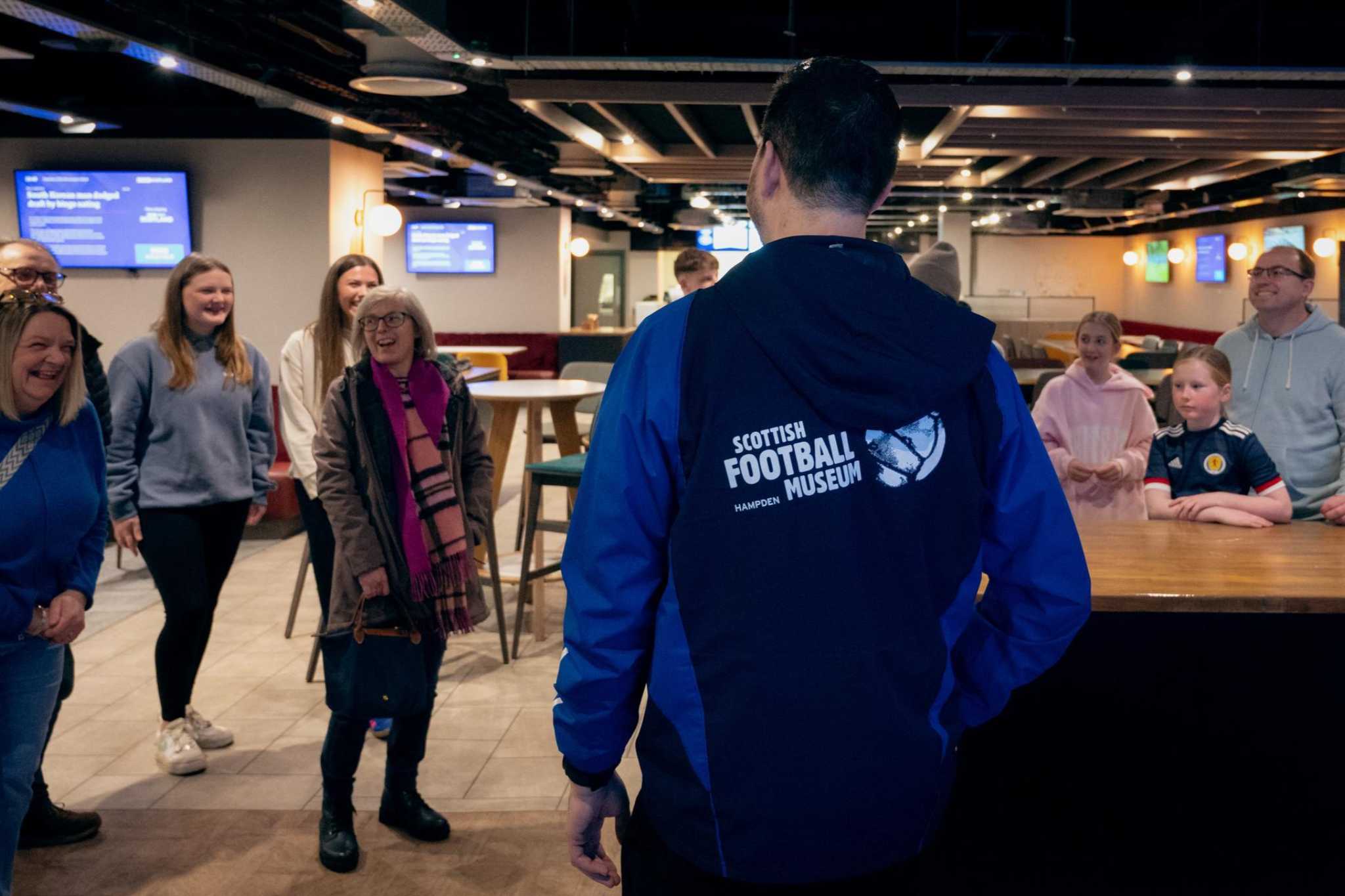 A tour group at the Scottish Football Museum enjoy listening to the tour guide