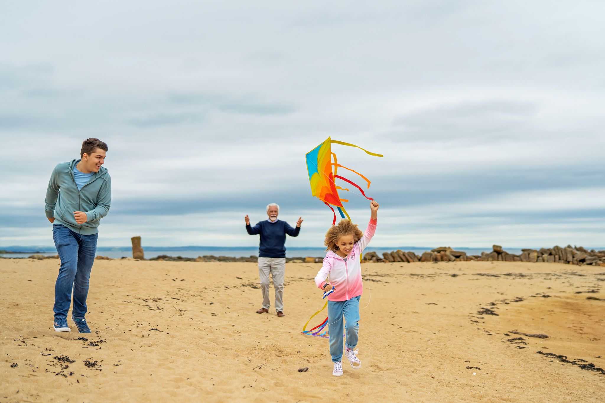 A family flying a kite on the beach
