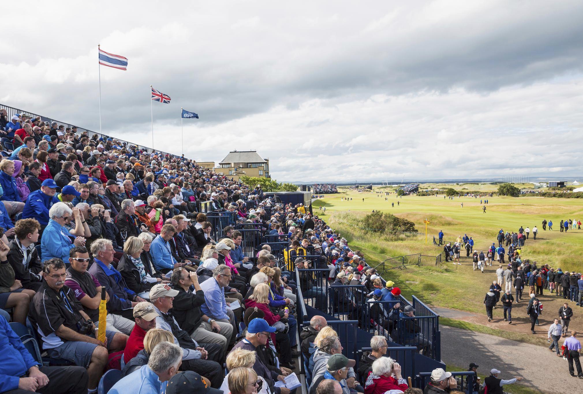 A large packed crowd watches on from the seated area at the Open Golf championship