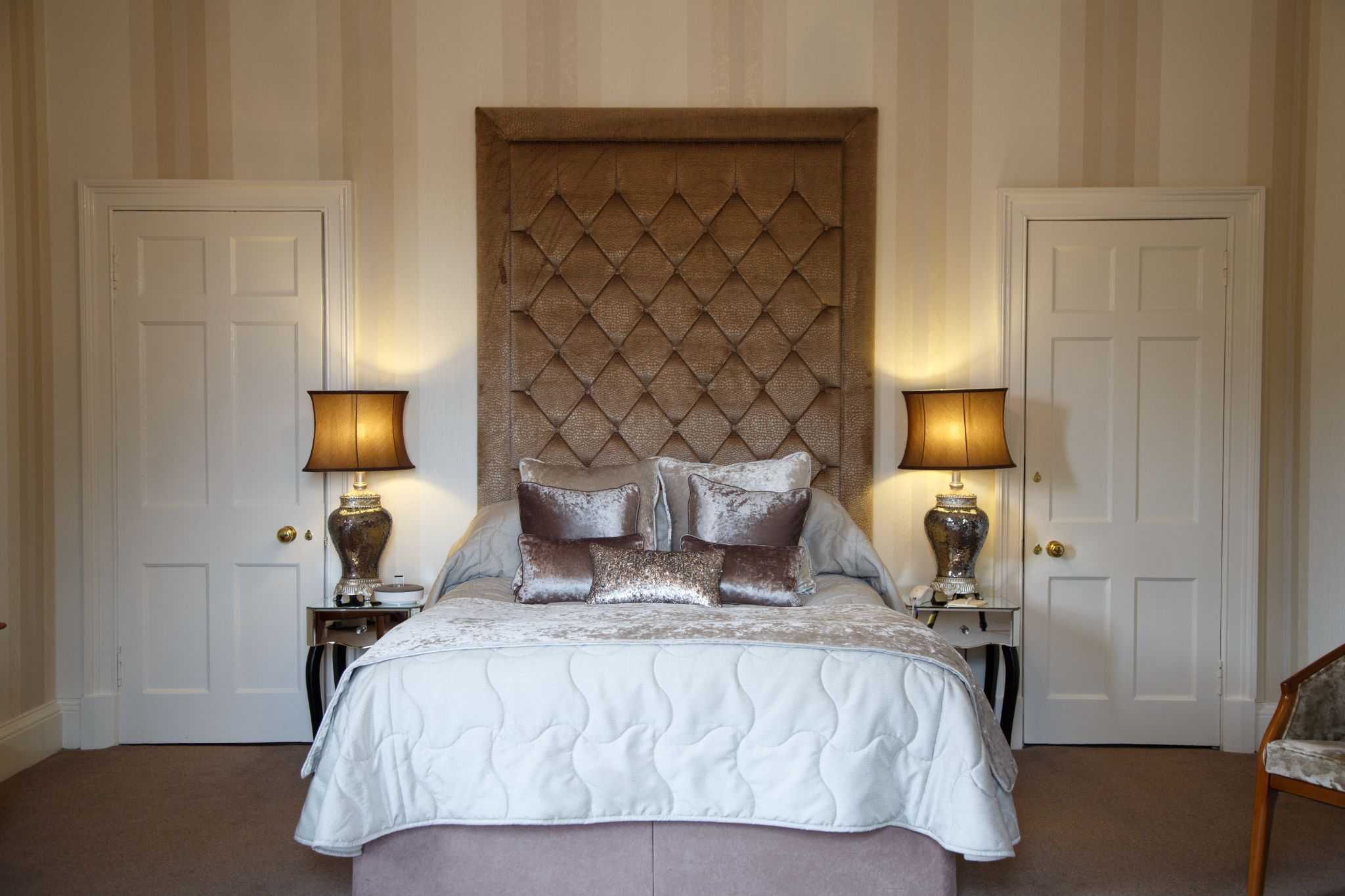 A double bed with lit bedside lamps and matching decor