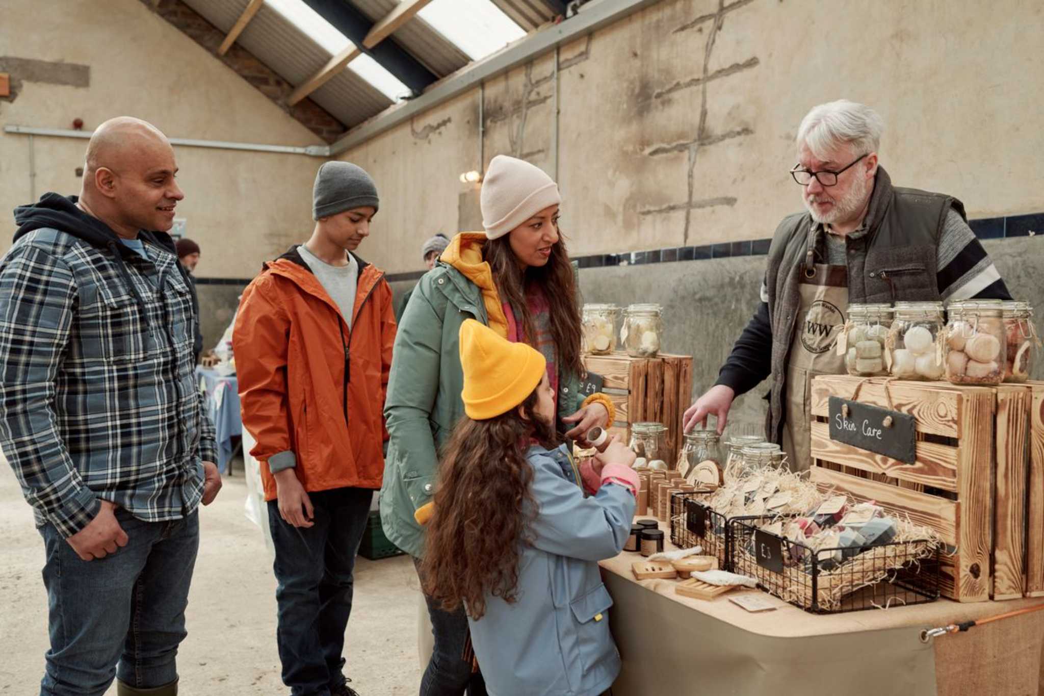 A family browsing skin care products at a farm shop