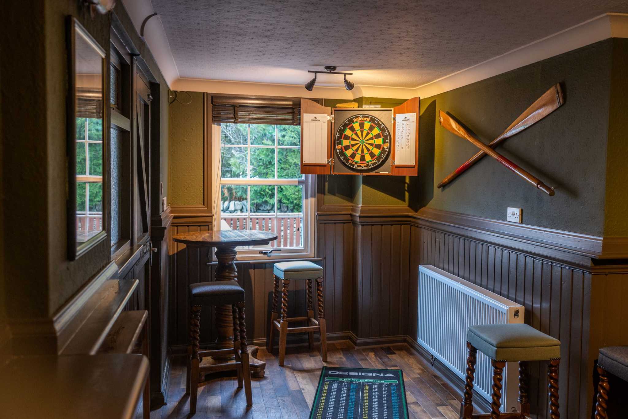 A dartboard in a pub is lit by light flooding through a window